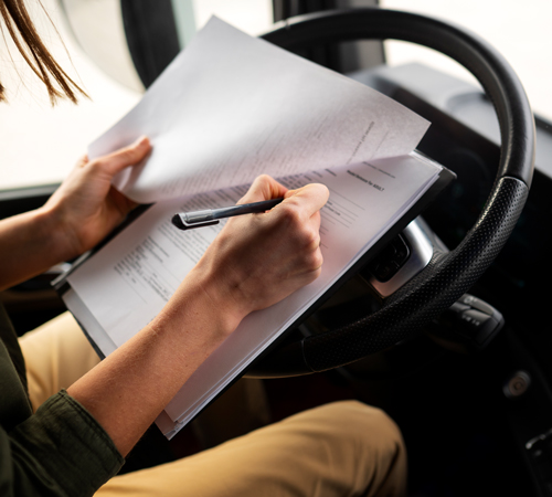 Conductor firmando albarán de transporte al volante